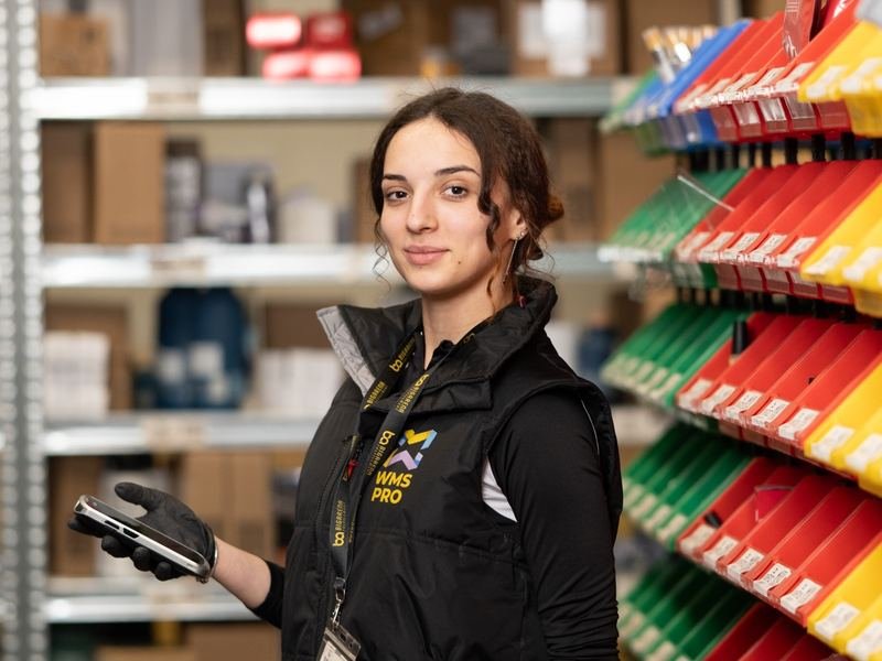 BigArena team member in the warehouse with a handheld scanner